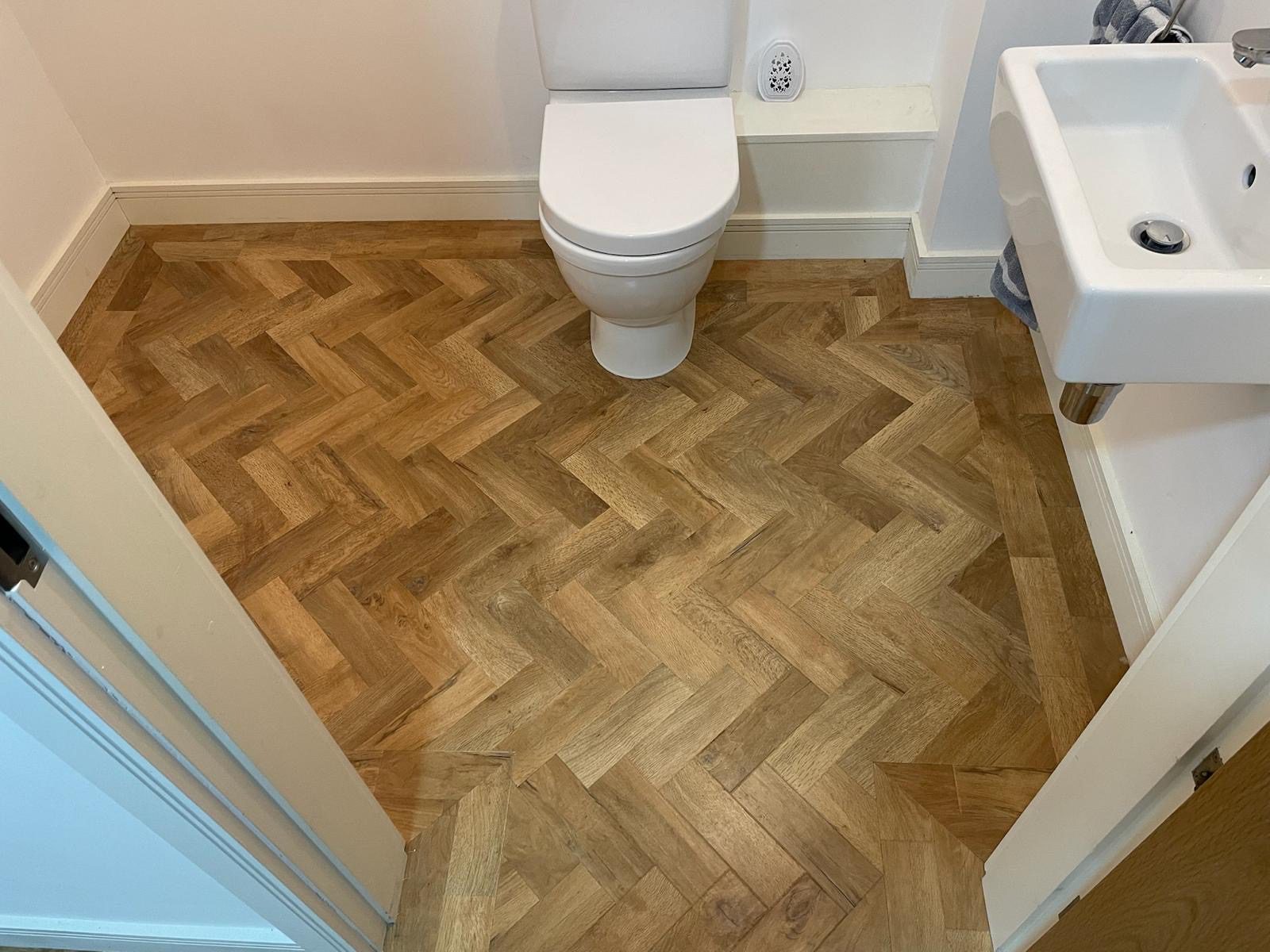 Parquet style LVT flooring installed near toilet area